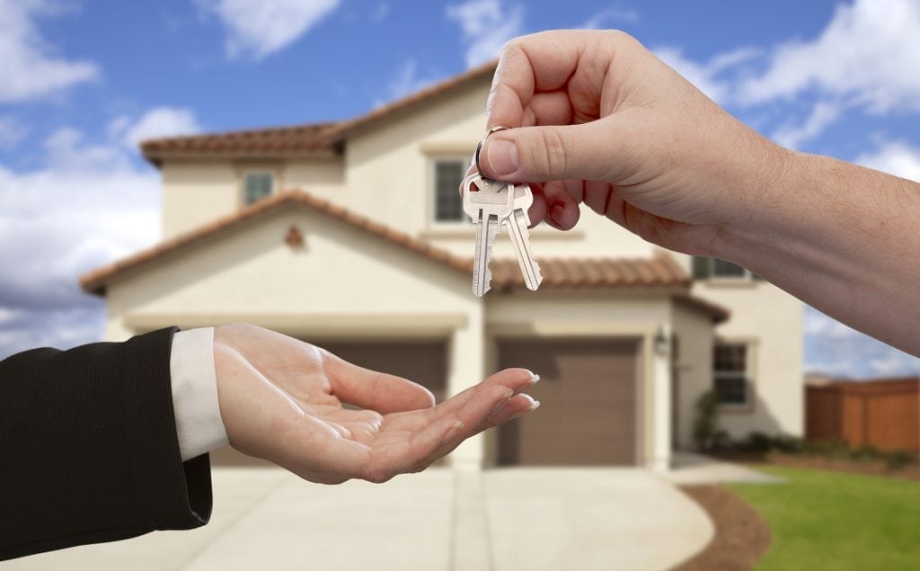 Handing Over the House Keys in Front of New Home