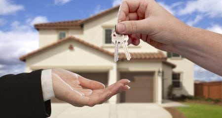 Handing Over the House Keys in Front of New Home