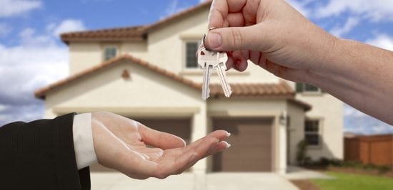 Handing Over the House Keys in Front of New Home